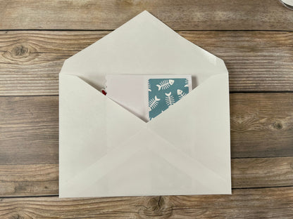 Open beige envelope with a card inside on a wooden surface