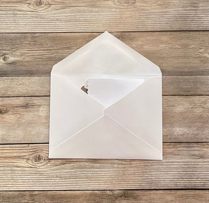 White envelope with a heart cutout on a wooden surface