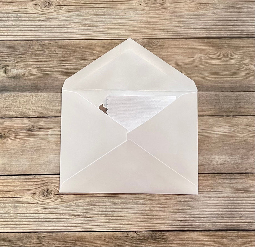 White envelope with a heart cutout on a wooden surface