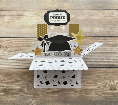 Graduation-themed decorative box with 'We are so proud of you!' and 'Graduation Day' text on a wooden surface.