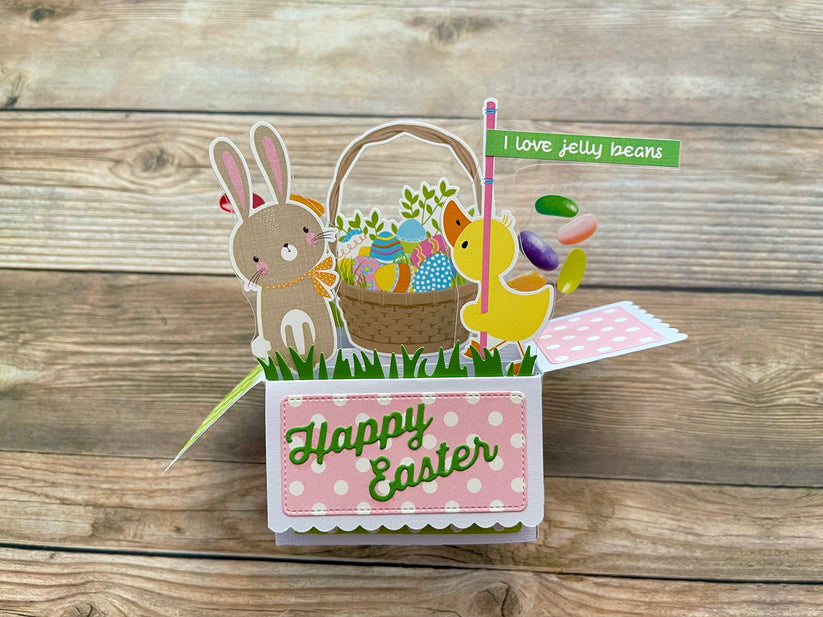 Easter-themed pop-up card with bunny, chick, and basket on a wooden surface