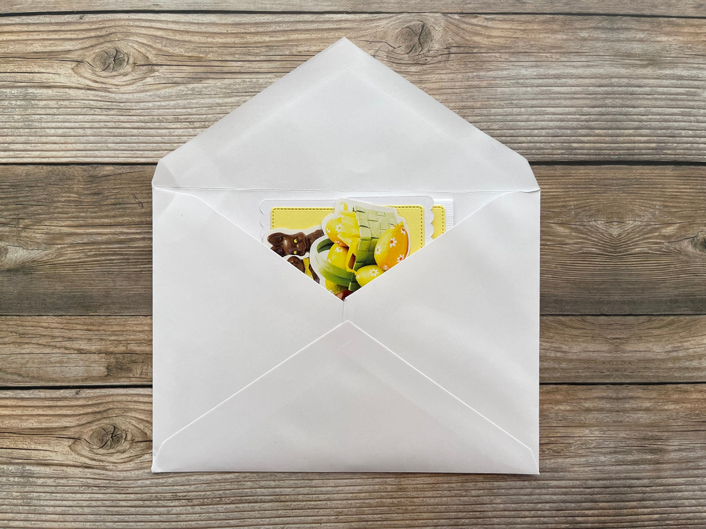 White envelope with a colorful card on a wooden surface