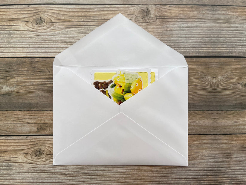 White envelope with a colorful card on a wooden surface