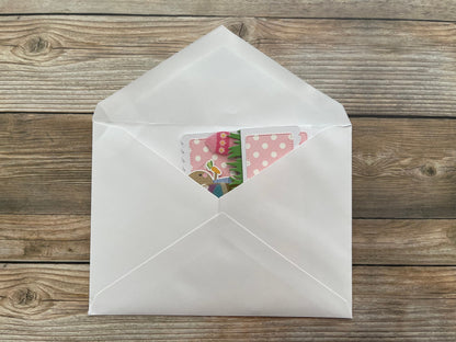 Open white envelope with colorful cards on a wooden surface