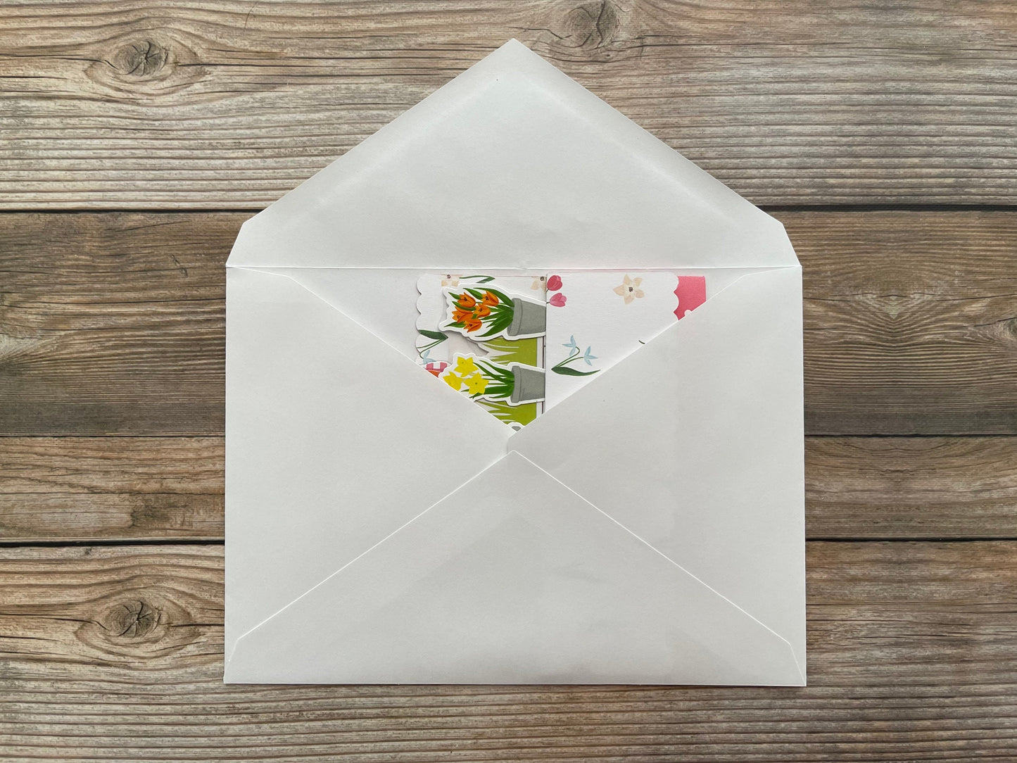 White envelope with floral design on a wooden surface