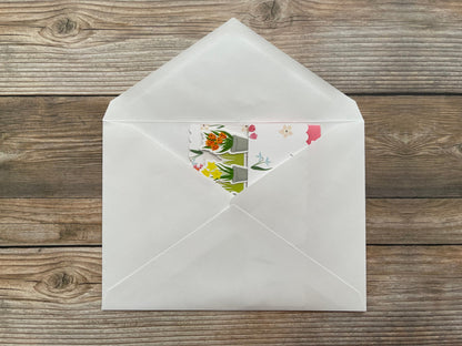 White envelope with floral design on a wooden surface