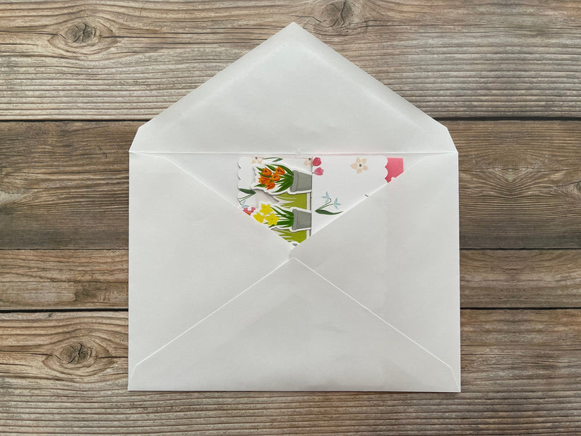White envelope with floral design on a wooden surface