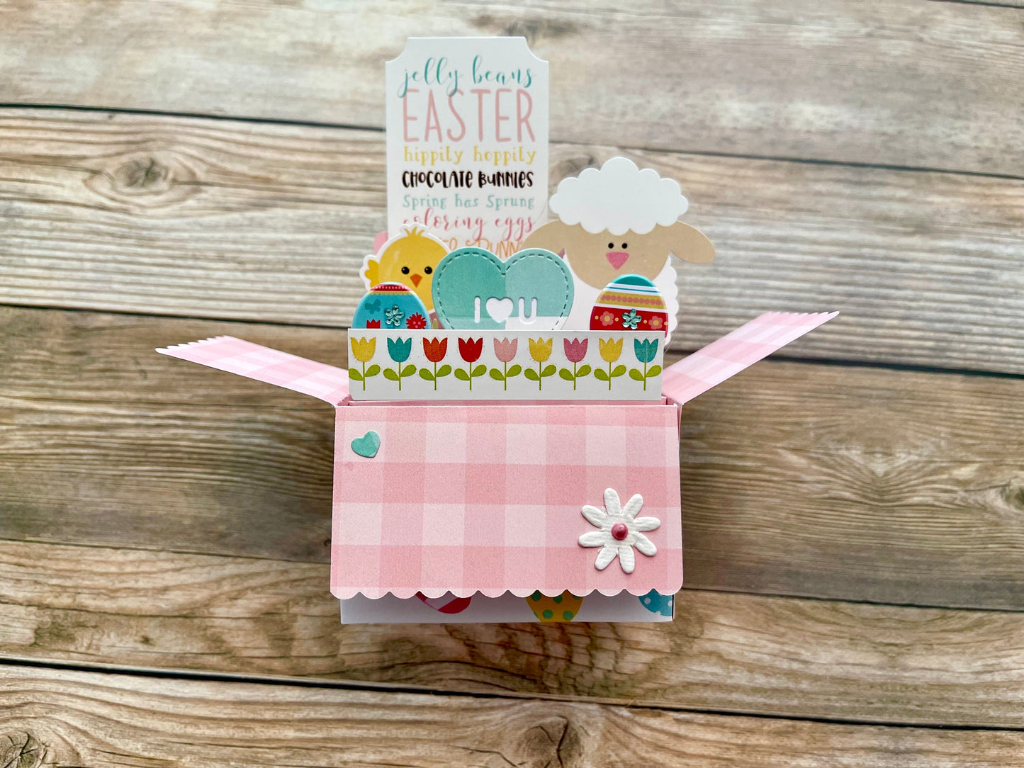 Decorative Easter card with a sheep design on a wooden surface