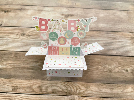 Baby-themed pop-up card on a wooden surface