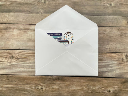 White envelope with a baby card inside on a wooden surface