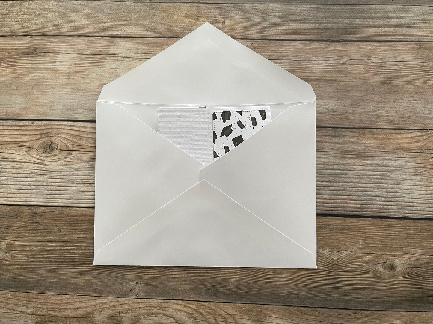 White envelope with a black and white patterned card on a wooden surface