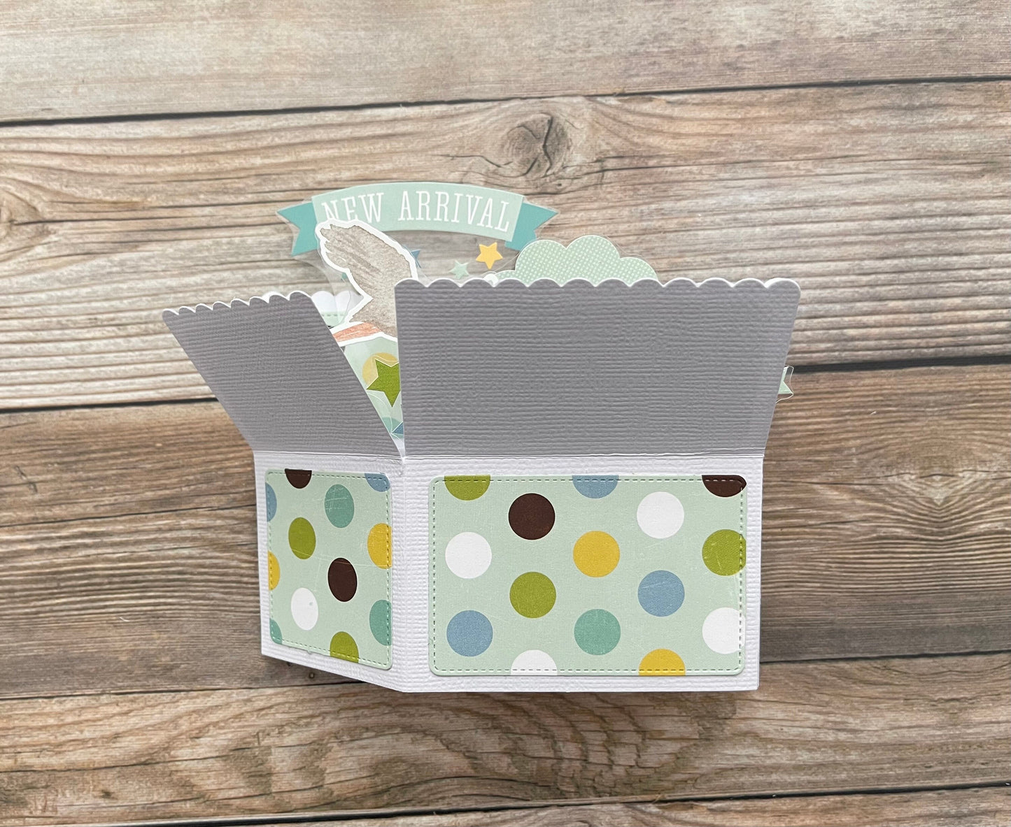 Open card with colorful polka dot design on a wooden surface