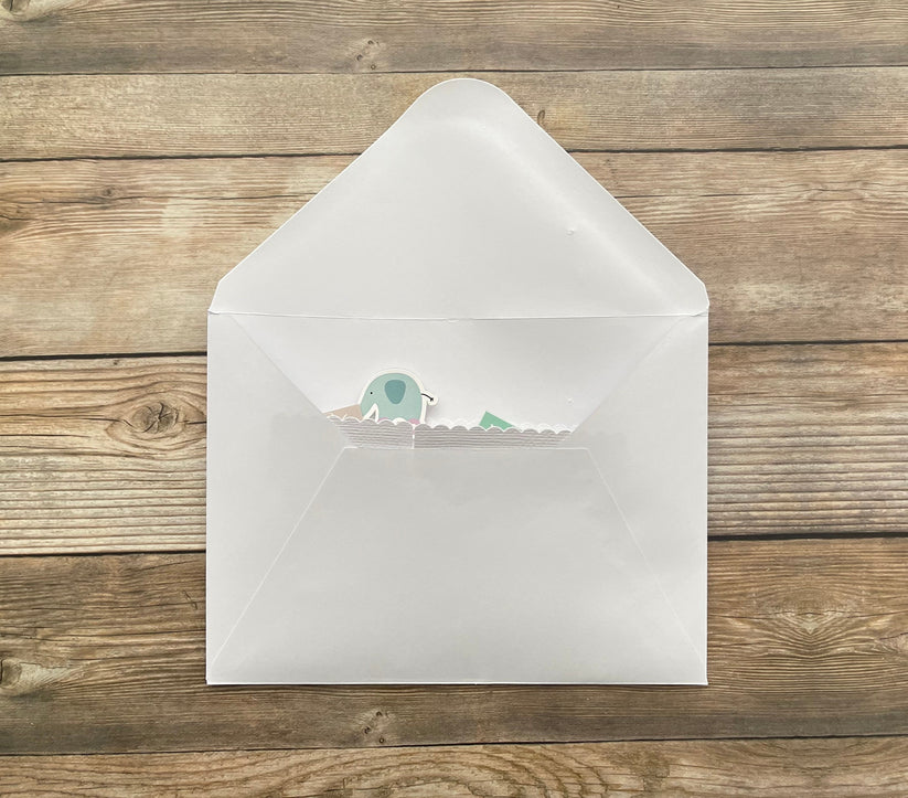 White envelope with a small green and white sticker on a wooden surface