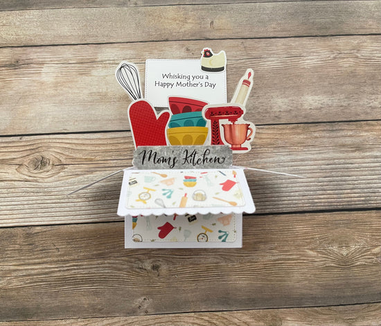 Mother's Day pop-up card with kitchen-themed elements and a message on a wooden surface