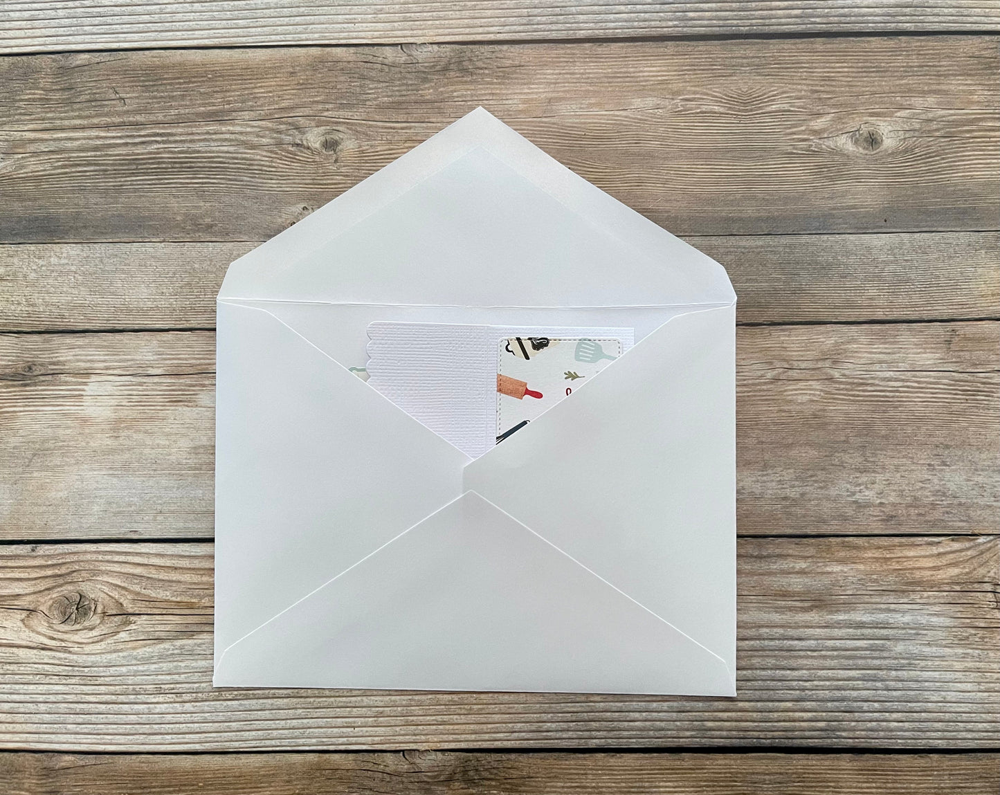 White envelope with a card inside on a wooden surface