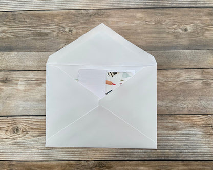 White envelope with a card inside on a wooden surface