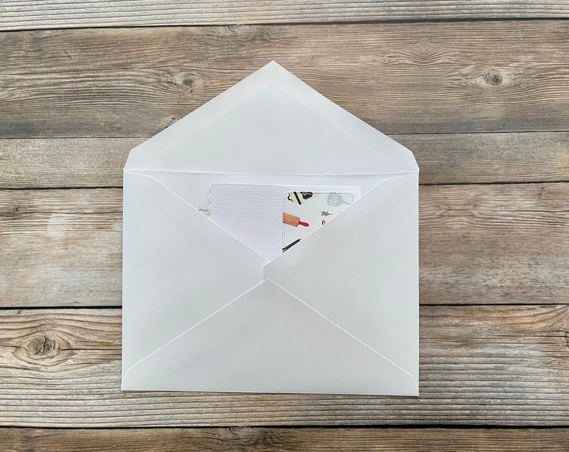 White envelope with a card inside on a wooden surface