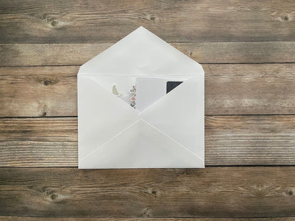 White envelope with a card on a wooden surface