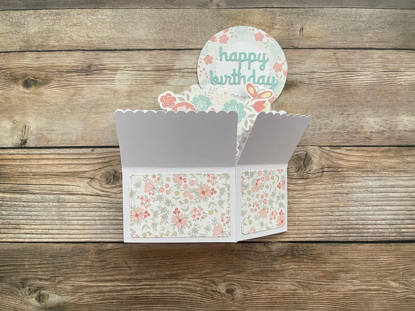Floral birthday card with a scalloped edge on a wooden surface