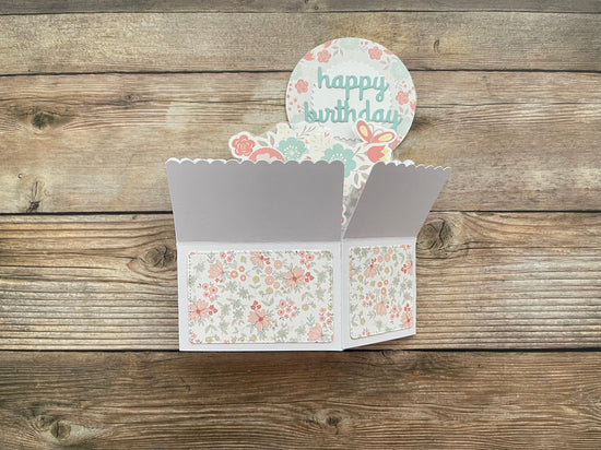 Floral birthday card with a scalloped edge on a wooden surface