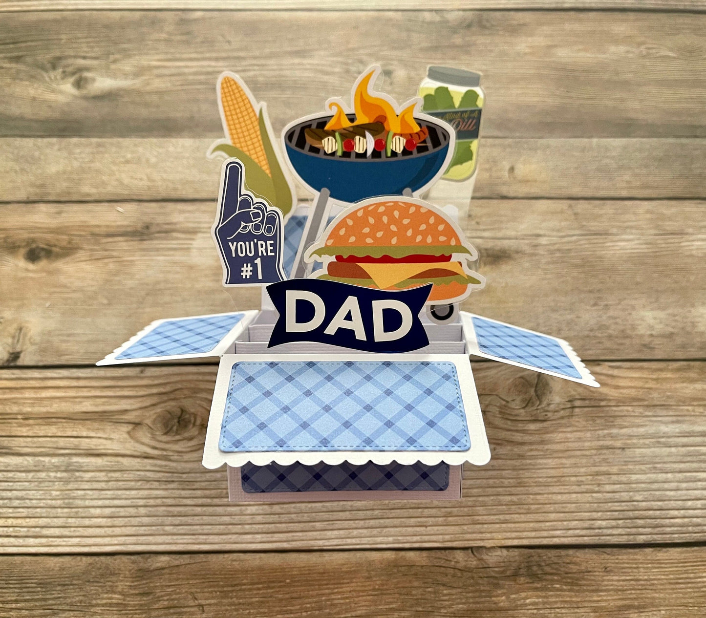 Pop-up card with grill, burger, and 'You're #1 Dad' text on a wooden background