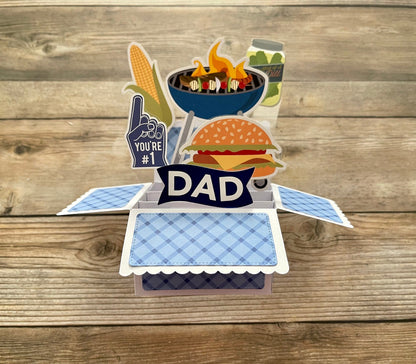 Pop-up card with grill, burger, and 'You're #1 Dad' text on a wooden background