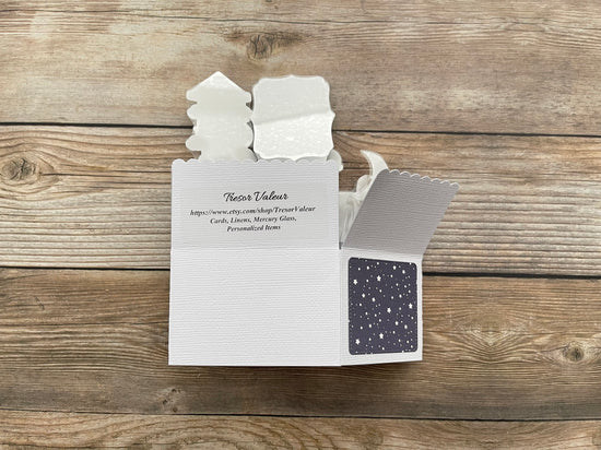 White card with text and a small black square on a wooden surface