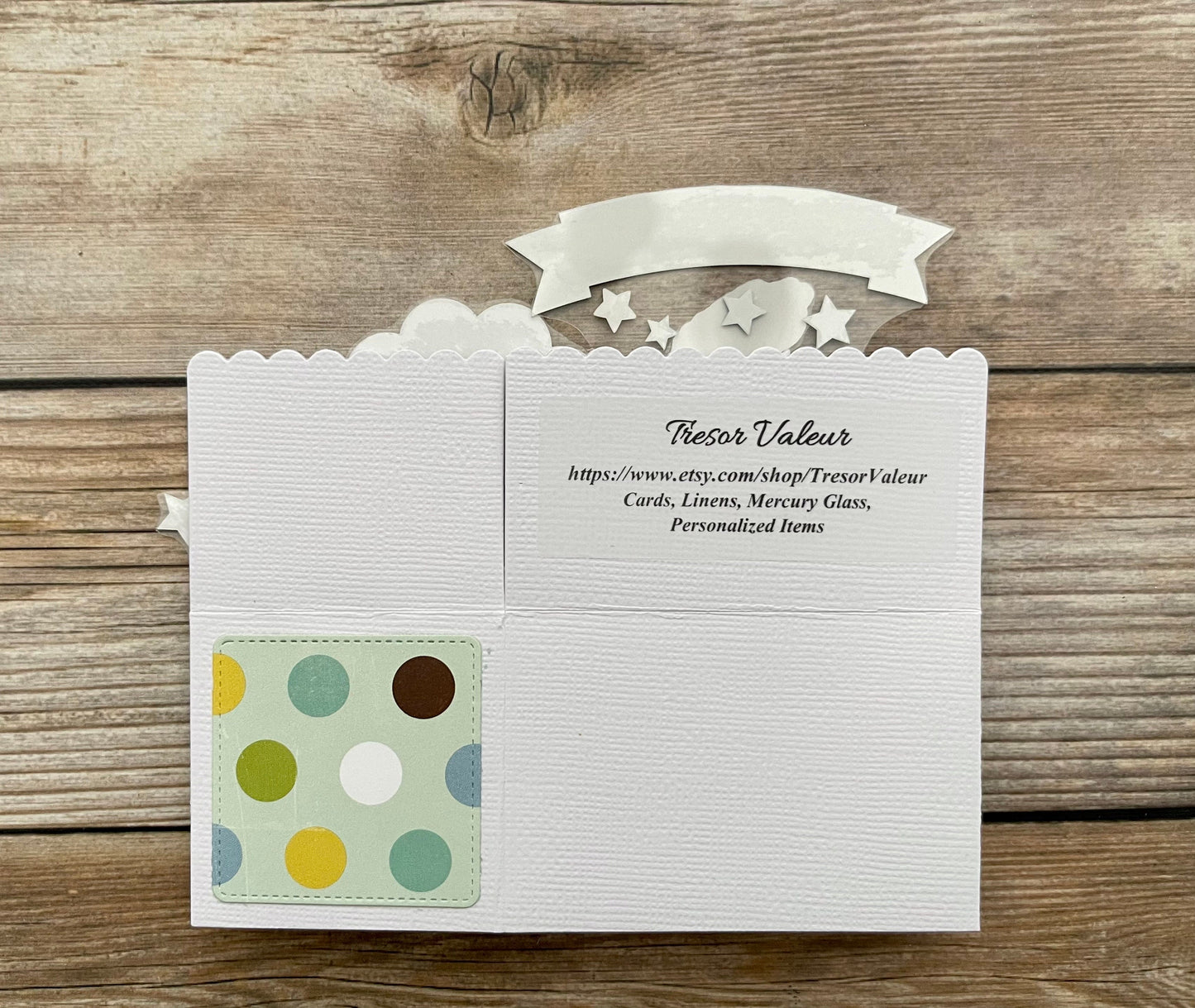 White card with a colorful polka dot design on a wooden surface