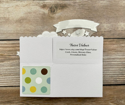 White card with a colorful polka dot design on a wooden surface