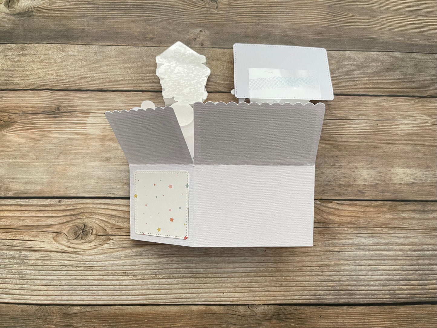 Open white card with scalloped edges on a wooden surface