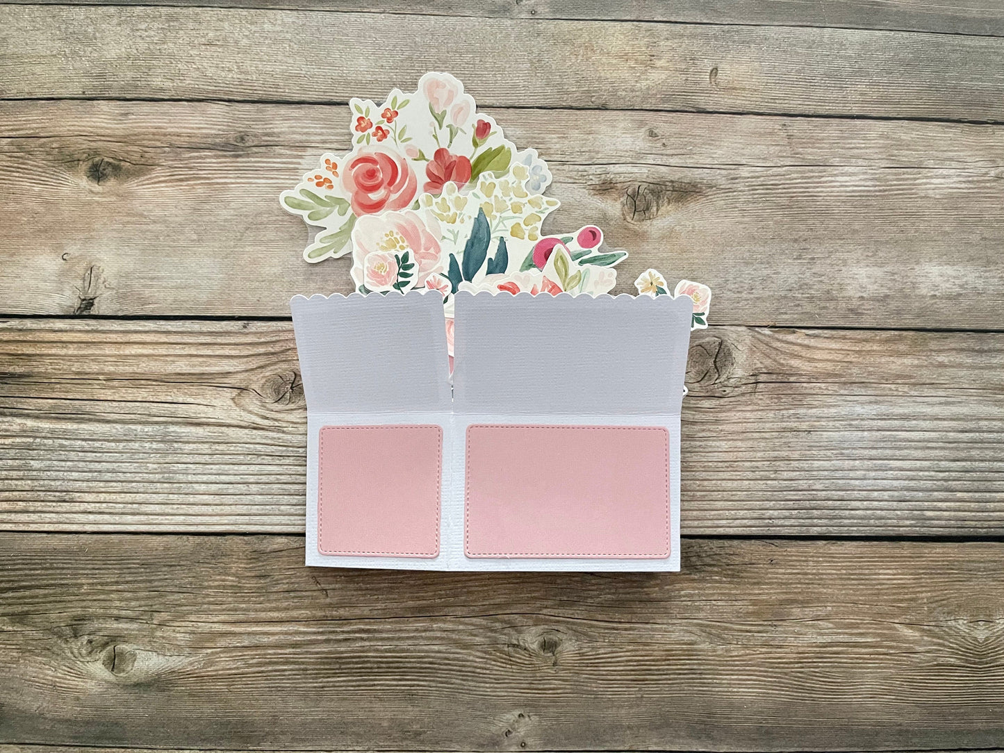 Box style pop-up card folded flat to show the outside on a wooden table.