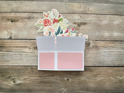 Box style pop-up card folded flat to show the outside on a wooden table.