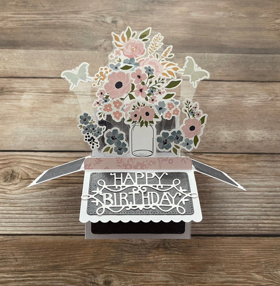 3D floral birthday card on a wooden surface