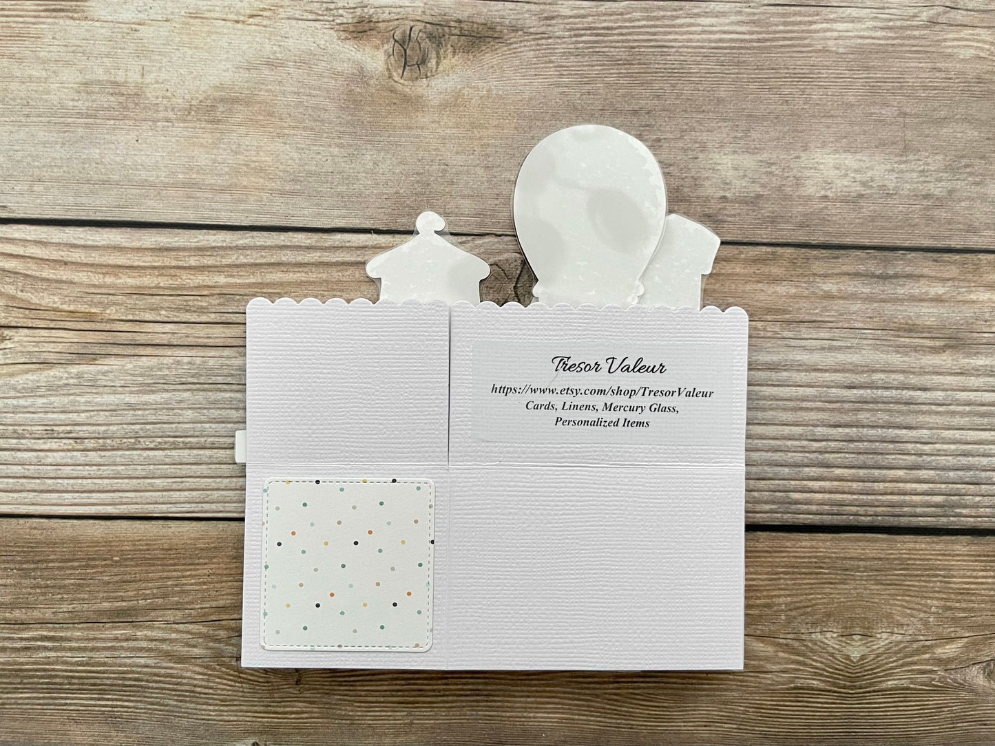 White card with cut-out figures on a wooden surface