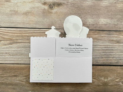 White card with cut-out figures on a wooden surface