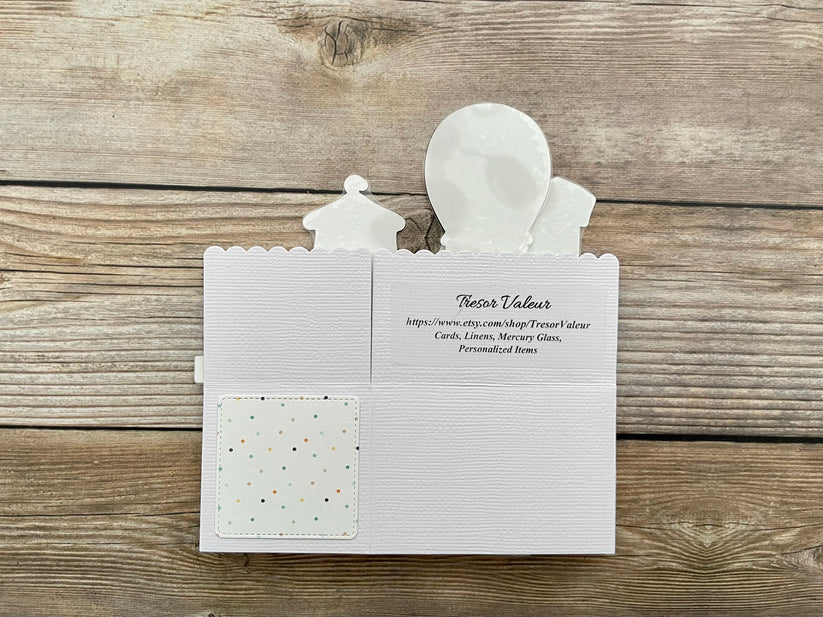 White card with cut-out figures on a wooden surface