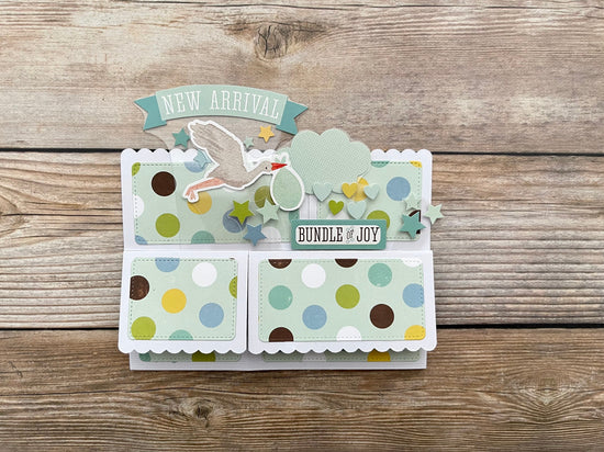 Folded 3D box pop-up card with polka dots and text on a wooden surface