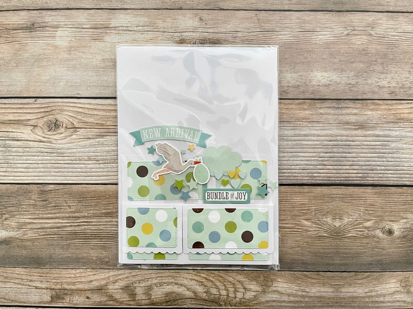 Baby shower card with polka dots and text on a wooden surface