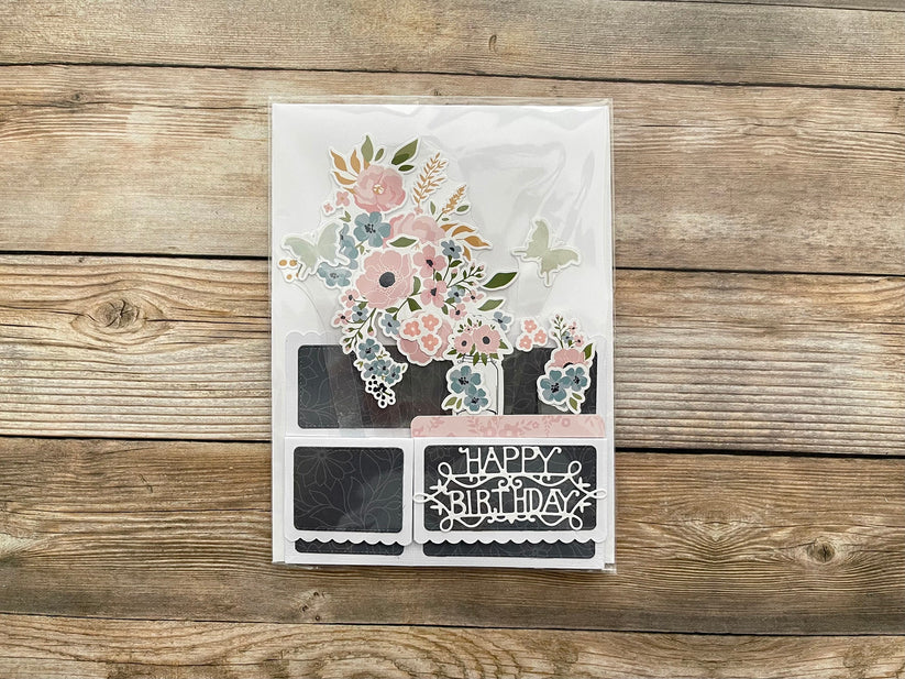 Decorative birthday card with floral design and 'Happy Birthday' text on a wooden surface
