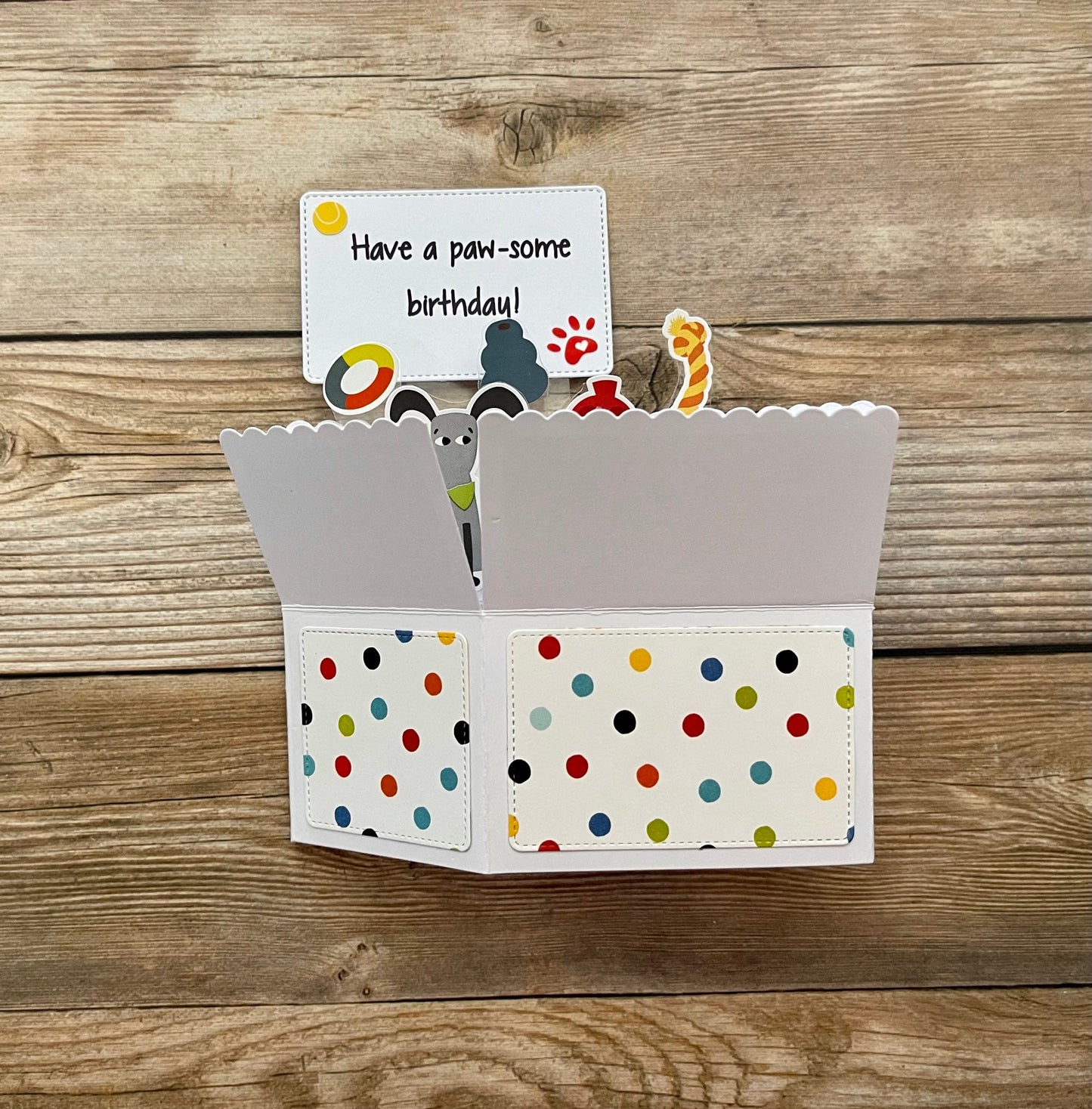 Polka dot card holder with a small card on a wooden surface