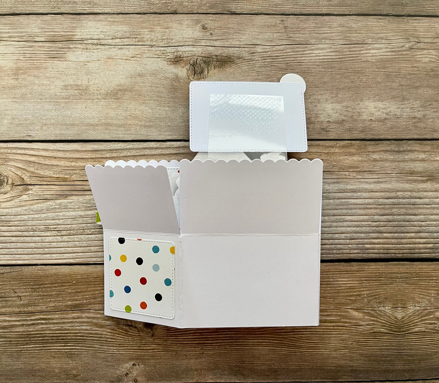 White card with colorful polka dot design on a wooden surface