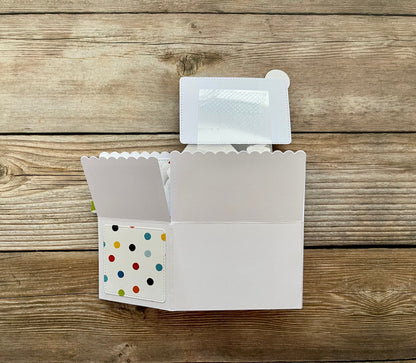 White card with colorful polka dot design on a wooden surface