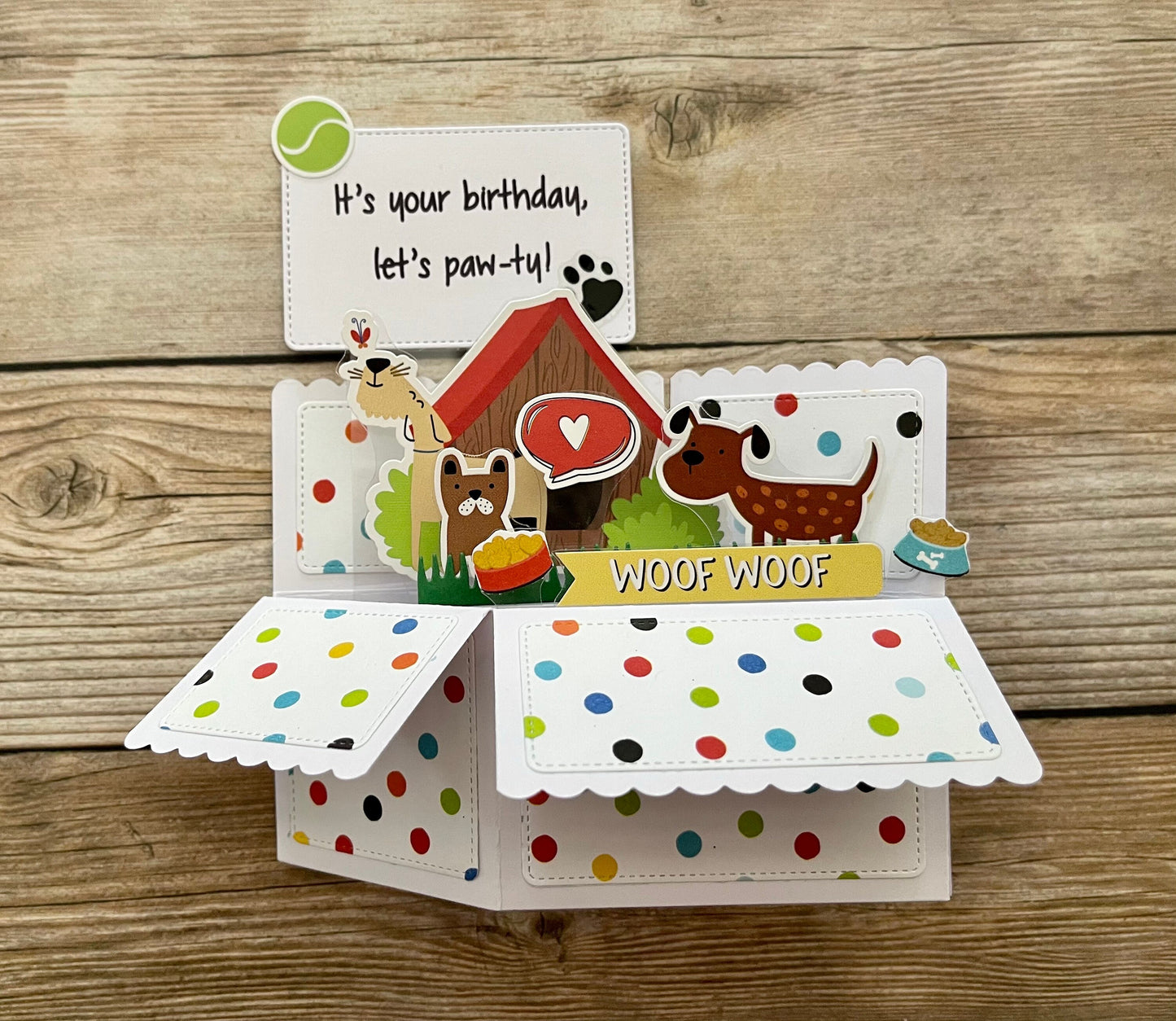 Dog-themed birthday card with colorful polka dot interior on a wooden background