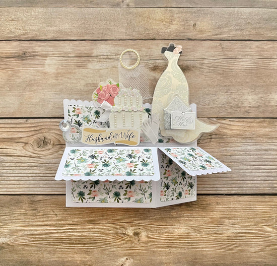 Pop-up card with wedding theme on a wooden surface