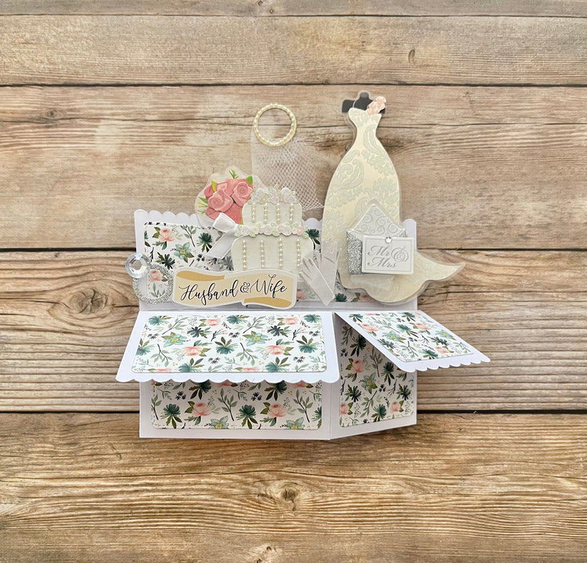 Pop-up card with wedding theme on a wooden surface
