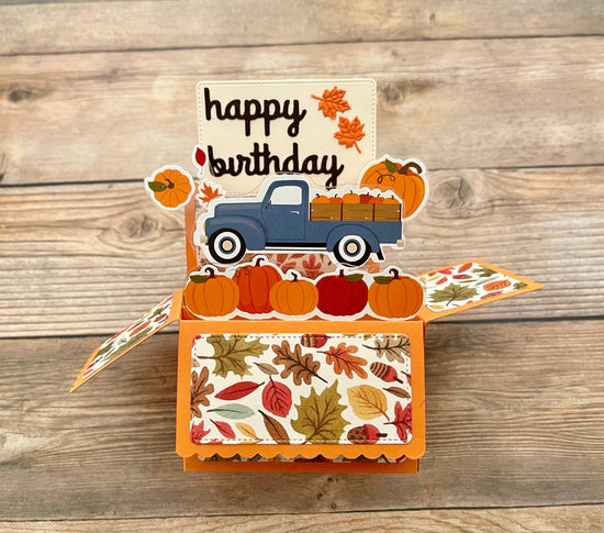 Birthday card with a blue truck and pumpkins on a wooden background