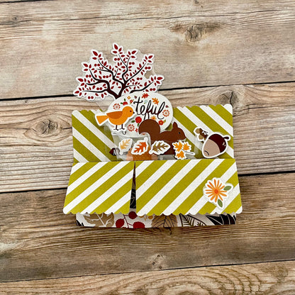 3D box pop-up card with autumn-themed stickers on a wooden surface