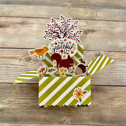 3D box pop-up card with autumn-themed stickers on a wooden background