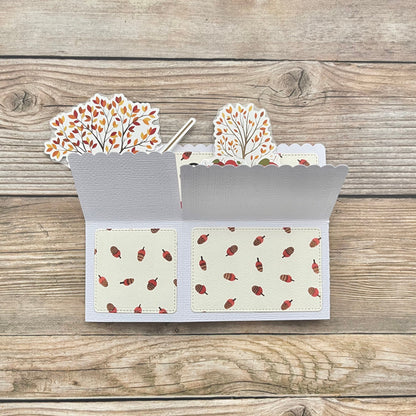 Card with autumn-themed design on a wooden surface
