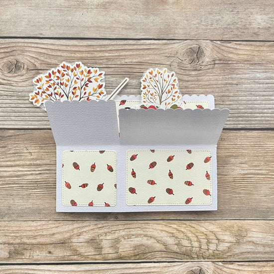 Card with autumn-themed design on a wooden surface